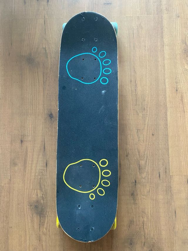 Skate con huellas azules y amarillas.