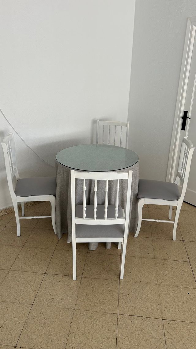 Mesa redonda con 4 sillas blancas