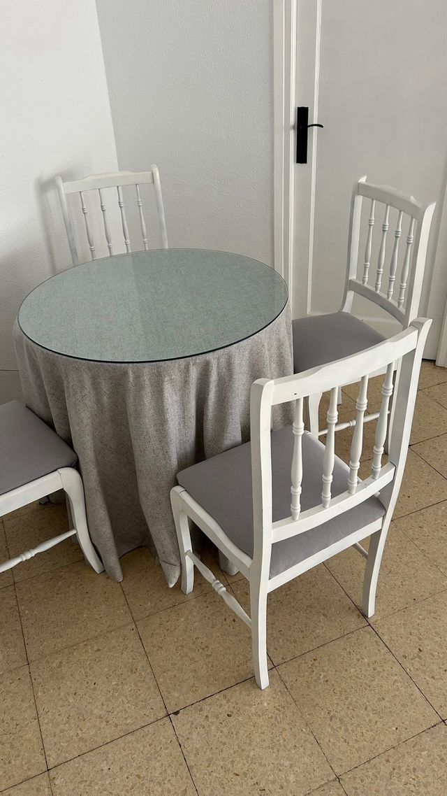 Mesa redonda con 4 sillas blancas