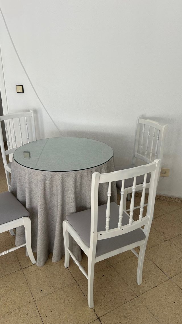 Mesa redonda con 4 sillas blancas
