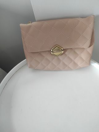 Bolso rosa acolchado con cadena dorada.