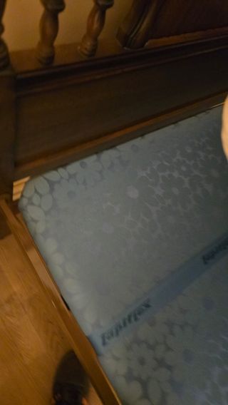 Cama de madera con colchon y colcha floral