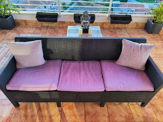 Sofá de jardín negro con cojines morado