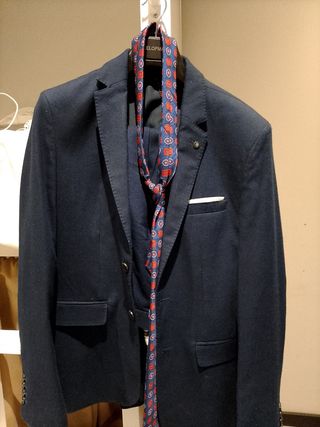 Traje azul con corbata roja