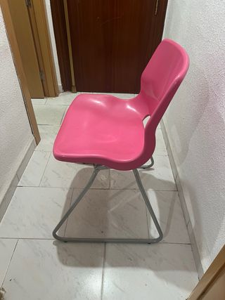Silla de plástico rosa con patas metálicas