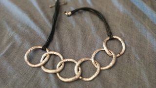 Collar de anillos plateados y cordón negro