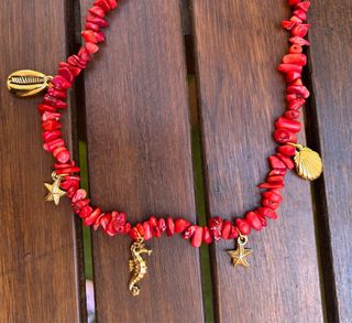 Collar de coral rojo con adornos en dorado.