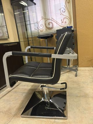 Silla de peluquería de cuero negra y plateada