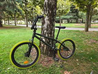 Bicicleta BMX verde con ruedas amarillas