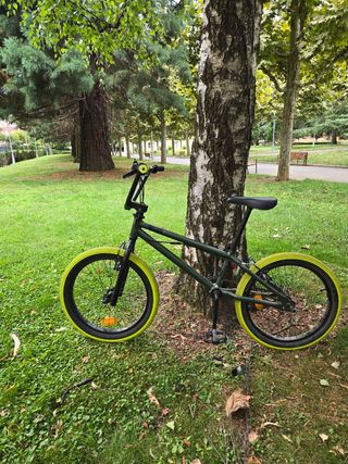 Bicicleta BMX verde con ruedas amarillas