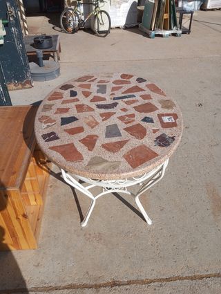 Mesa de patio redonda de piedra y metal