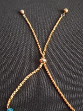 Pulsera ajustable con cuentas y dijes dorados