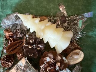 Centro de mesa navideño con vela y piñas