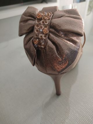 Zapatos de tacón dorados con lazo