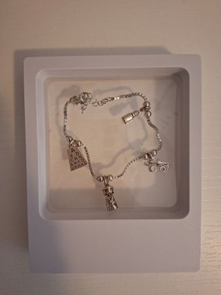 Pulsera plata con dijes de profesional de Óptica.