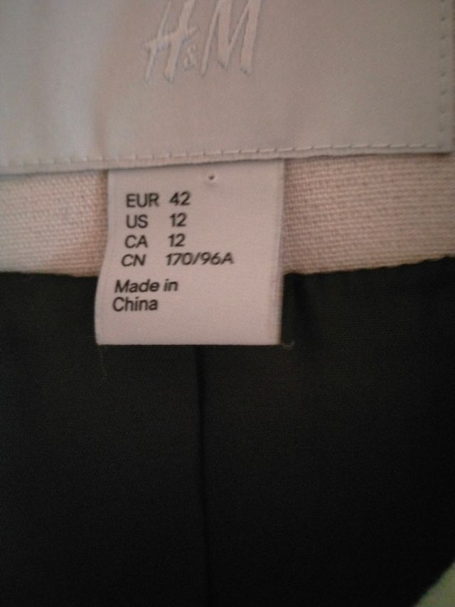 Abrigo beige con cinturón negro,