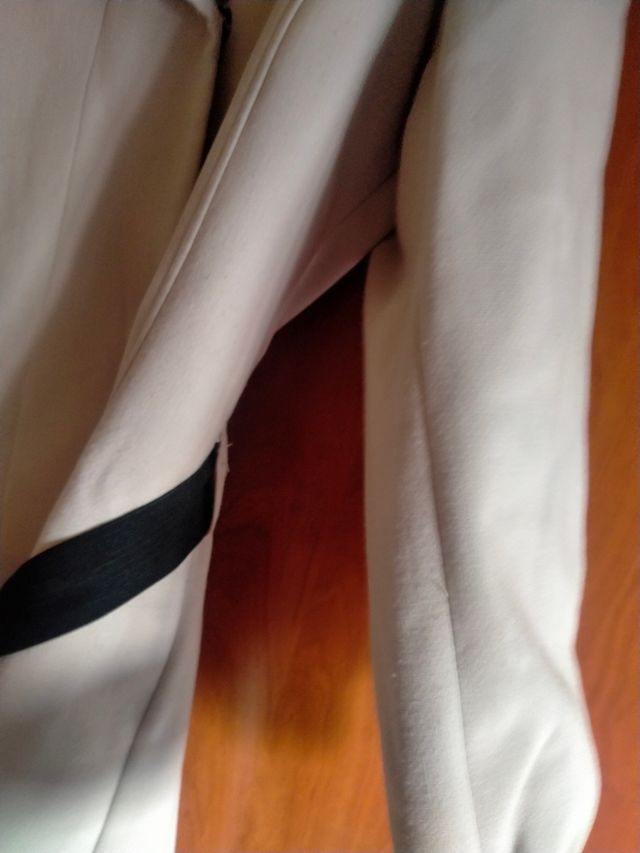 Abrigo beige con cinturón negro,