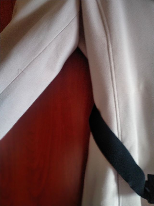 Abrigo beige con cinturón negro,