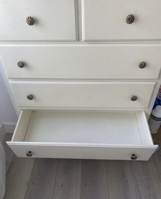 Cómoda de madera blanca con tiradores dorados
