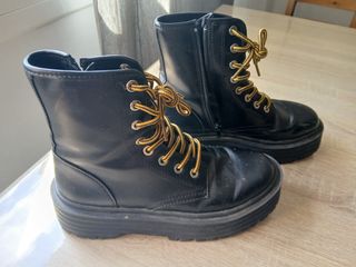 botas negras cordones amarillos