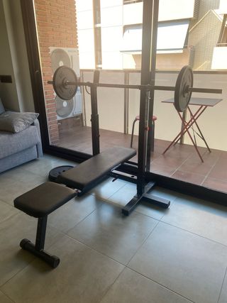 Banco de musculación con barra y discos