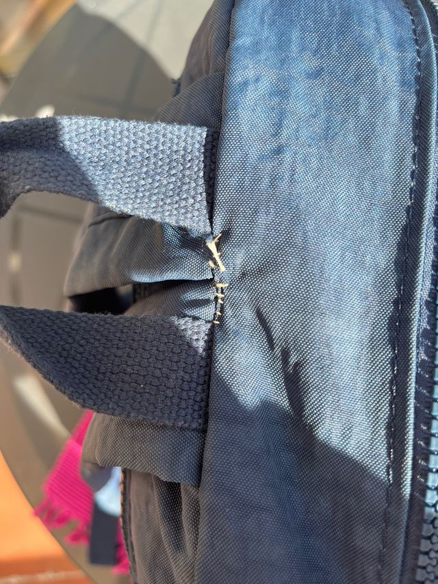 Mochila azul de tela con múltiples bolsillos.