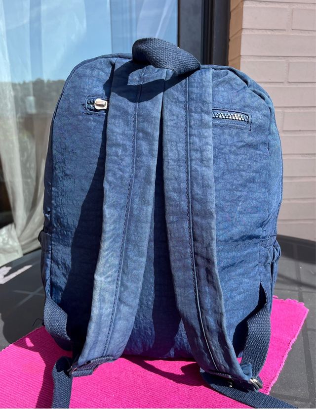 Mochila azul de tela con múltiples bolsillos.