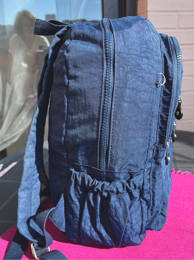 Mochila azul de tela con múltiples bolsillos.