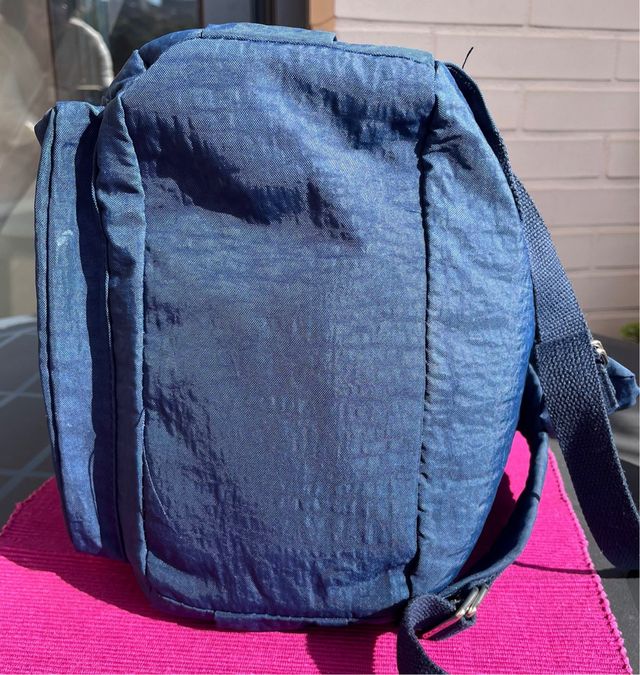 Mochila azul de tela con múltiples bolsillos.