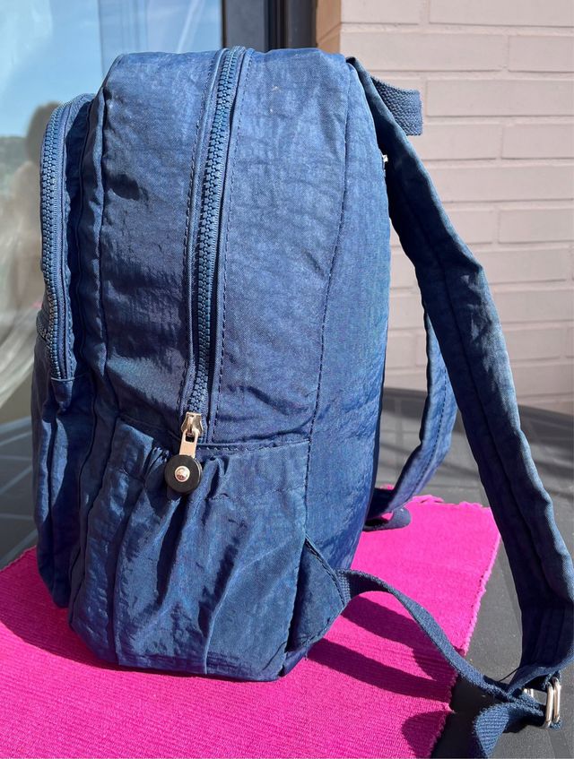 Mochila azul de tela con múltiples bolsillos.