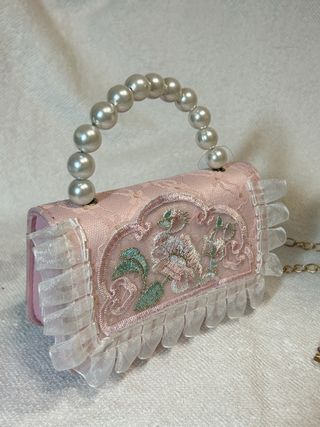 Bolso de mano rosa vintage con perlas y encaje.