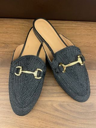 Mules Uterque negras con detalle dorado