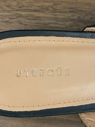 Mules Uterque negras con detalle dorado