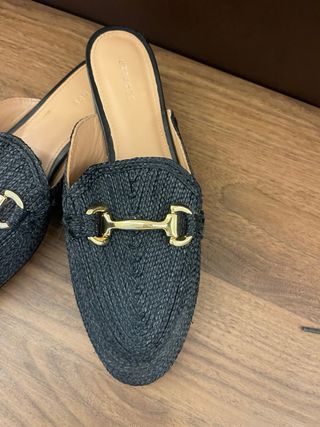 Mules Uterque negras con detalle dorado