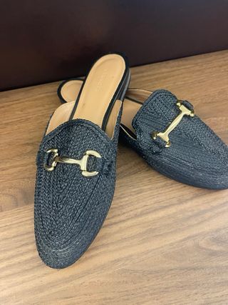 Mules Uterque negras con detalle dorado