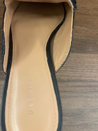 Mules Uterque negras con detalle dorado