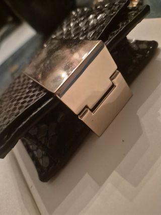 Mini bolso negro con cadena dorada.

