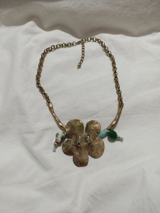 Collar dorado con flor y detalles verdes