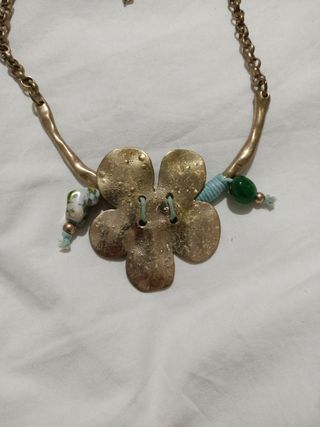 Collar dorado con flor y detalles verdes