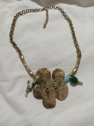 Collar dorado con flor y detalles verdes