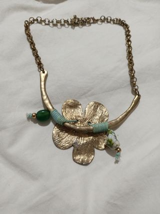 Collar dorado con flor y detalles verdes