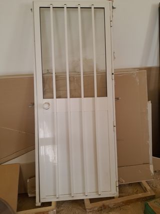 Puerta de aluminio blanca con rejas