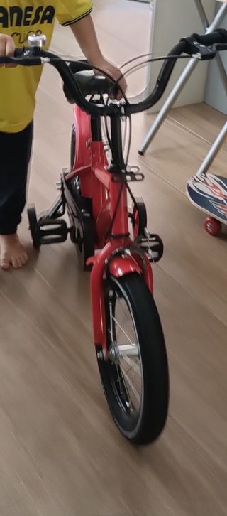 Bicicleta infantil roja con ruedines
