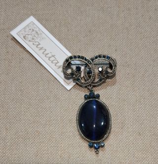 Broche plateado con piedra azul