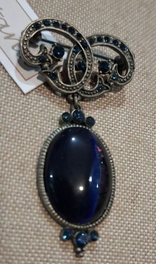 Broche plateado con piedra azul