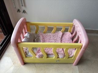 Cuna de juguete rosa y amarilla