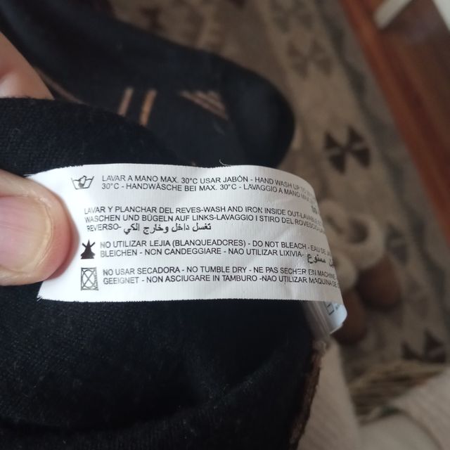 Chaqueta de punto negra con detalles dorados