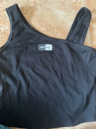 Top negro con etiqueta New Design