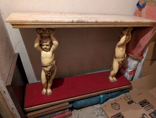 Recibidor madera y mármol con figuras de querubín
