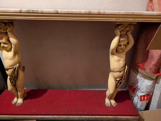 Recibidor madera y mármol con figuras de querubín